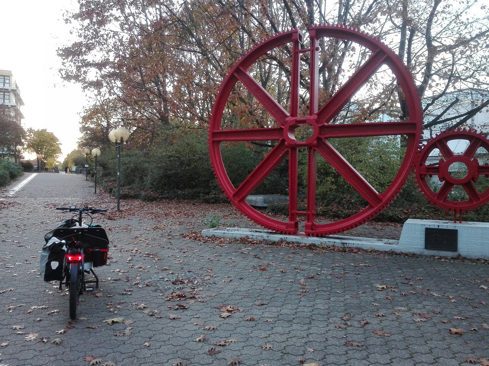 Auf dem Campus Nord der TU Dortmund: die Zahnräder. Näheres ist auf der Tafel nachzulesen.