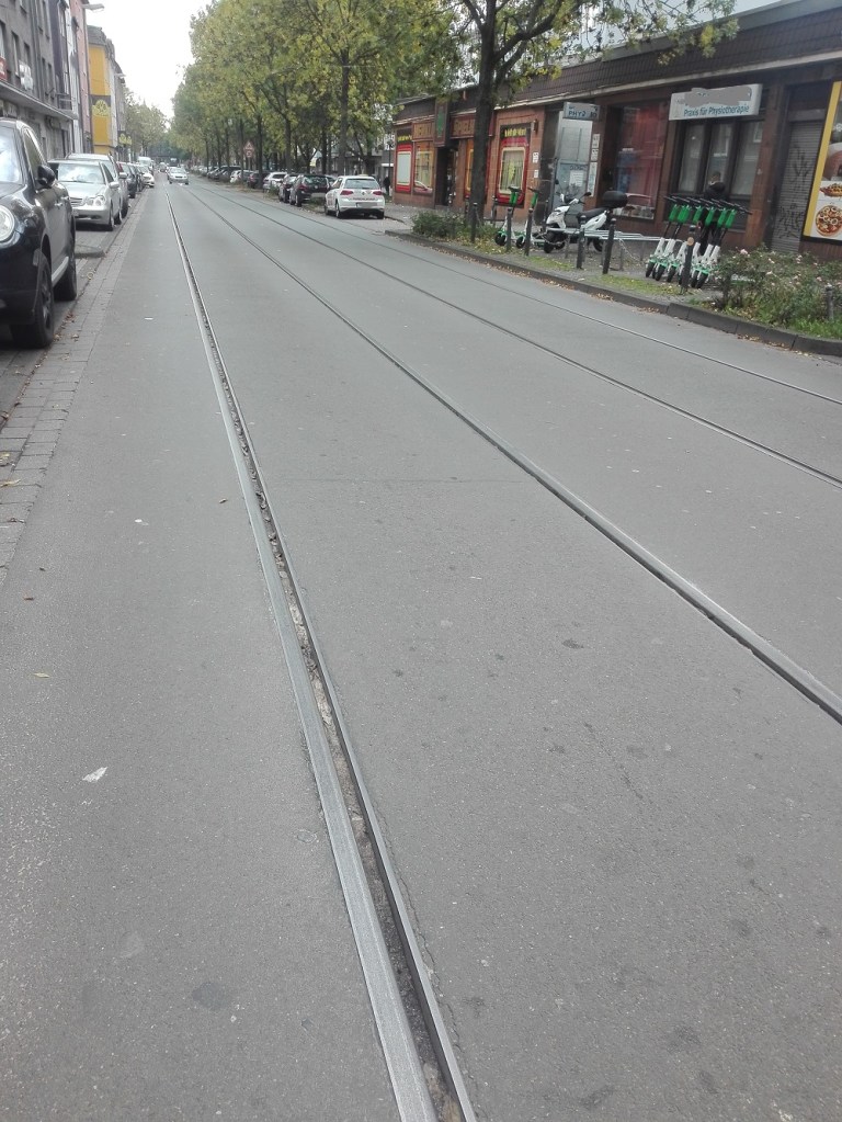 Schienen und Enge durch zuviele Parkplätze sorgen für eine unsichere Fahrt mit dem Rad. Straße Oestermärsch in Dortmund.